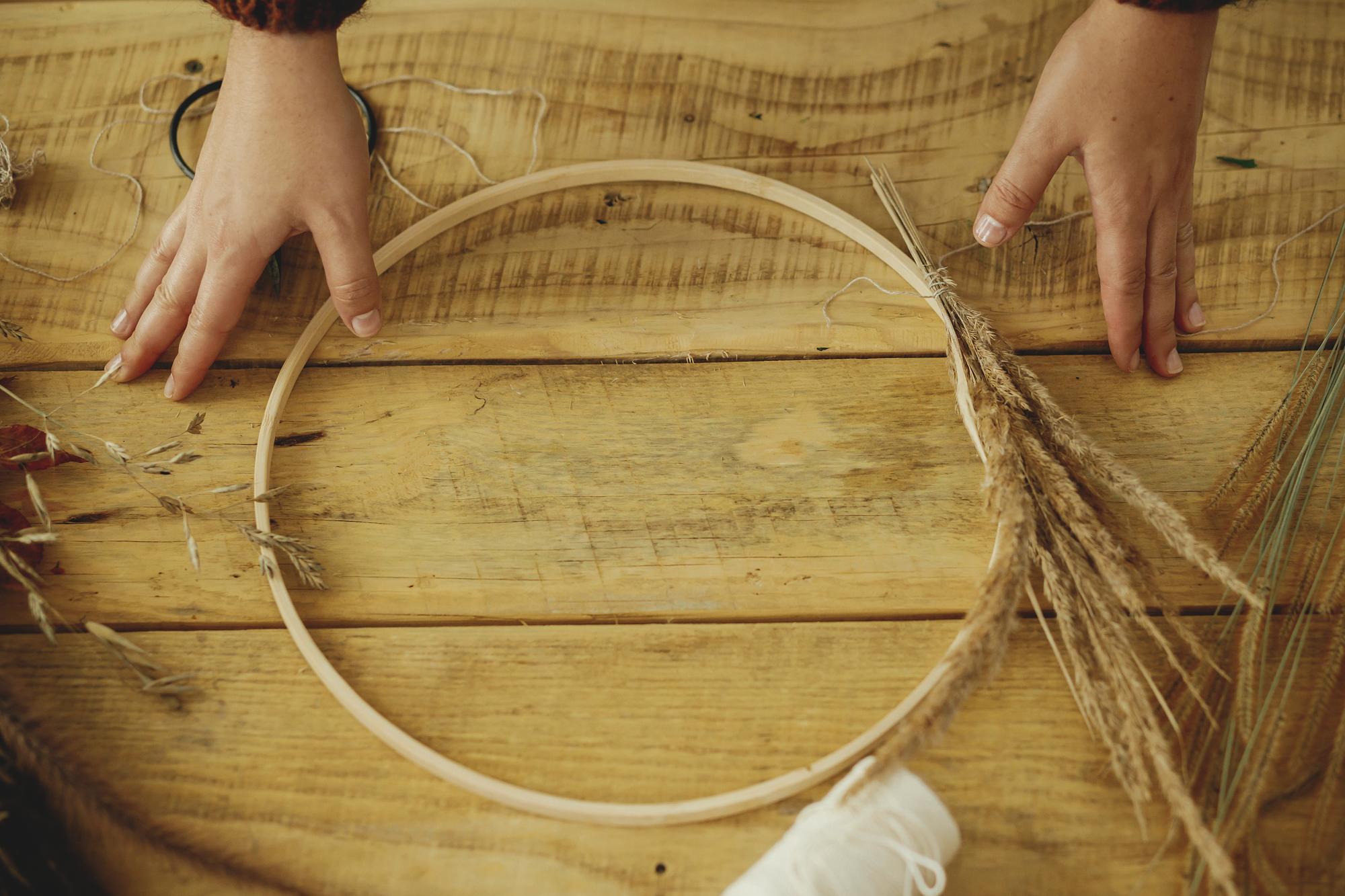 Master stitching on a wooden hoop in studio
