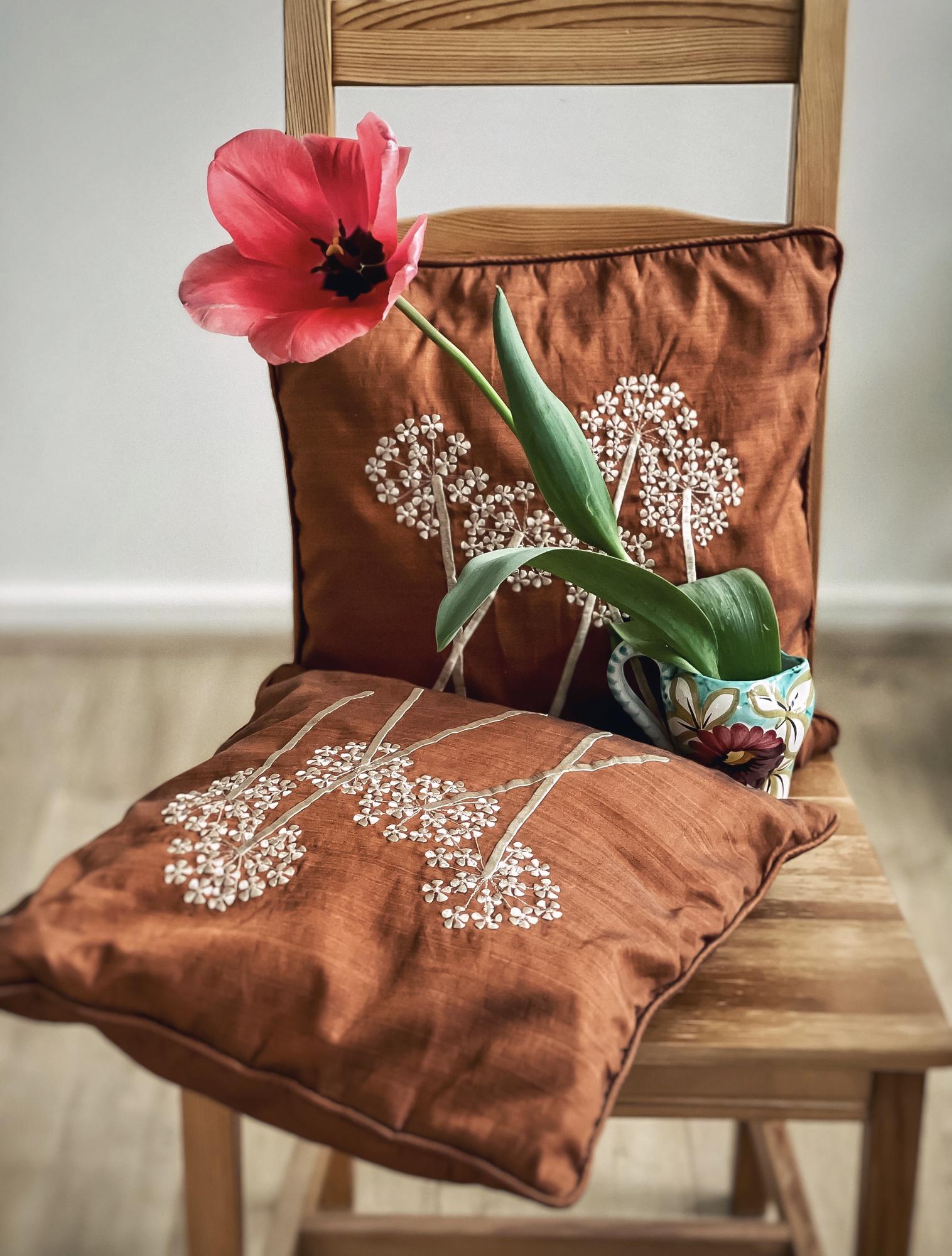 Decorative embroidered cushion in natural linen
